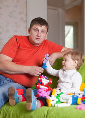 father and  three-year child plays  in home