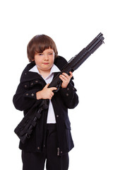 Portrait of handsome kid posing in studio with gun