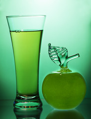 Apple juice and Apple on a green background