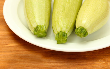 squash in white plate on wooden table close-up