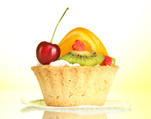 sweet cake with fruits on yellow background