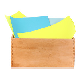 Wooden crate with colorful papers isolated on white