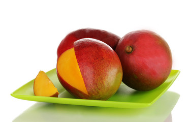 Ripe appetizing mango on green plate isolated on white