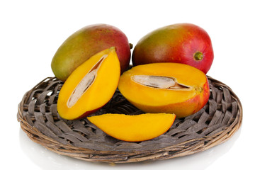 Ripe appetizing mango on wicker cradle isolated on white