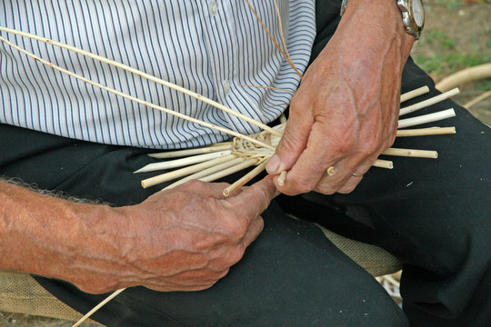 hands of the craftsman while working the rattan to make a wicker