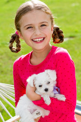 Best friends - happy girl with cute puppy in the garden