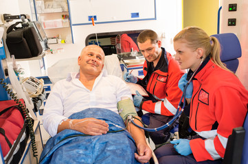 Paramedics checking patient pulse in emergency car