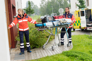 Fototapeta premium Paramedics carrying stretcher ambulance house call