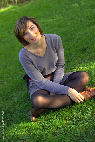 "jeune femme assise dans l'herbe" photo libre de droits sur la banque d