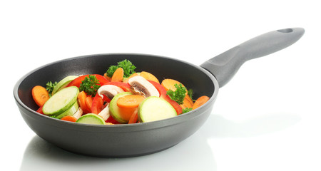 frying pan with vegetables on white