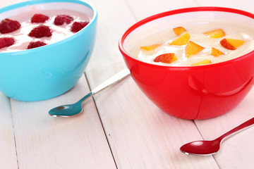 Yogurt with peaches and raspberries in bowls