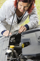 Fototapeta na wymiar Cute kobieta zmienia żarówki halogenowej w reflektorze samochodowym