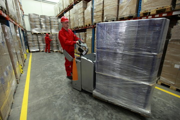 Two workers in uniforms  working in storehouse