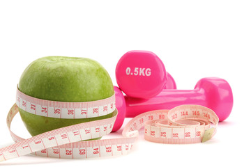 An apple, a measuring tape and dunbbell