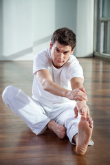 Young Man Stretching Leg At Gym