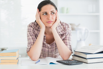 Woman holding her head on her hands while looking away