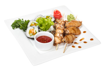 Buffalo chicken wings on plate with sushi
