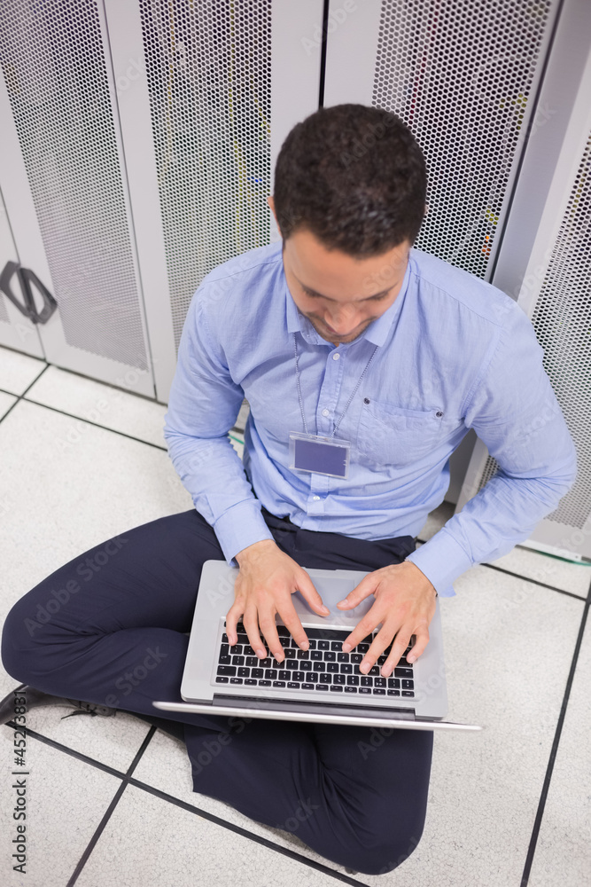 Poster Man using his laptop in data center