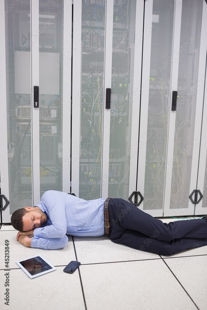 Poster technician sleeping in front of servers