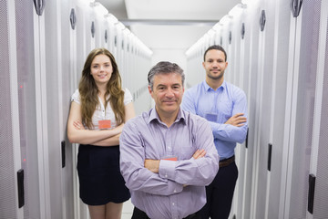 Three smiling people standing in data center