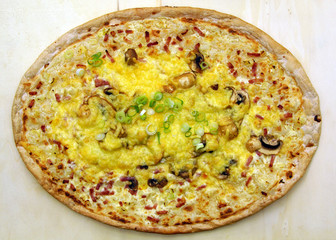 Frischer Flammkuchen auf Holzbrett