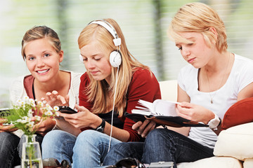 3 girls with different items on the sofa