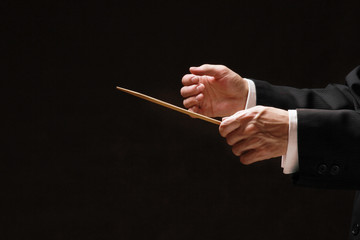 Concert conductor's hands with a baton