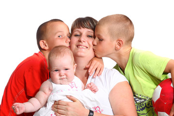 Happy woman with baby  while being kissed by her sons
