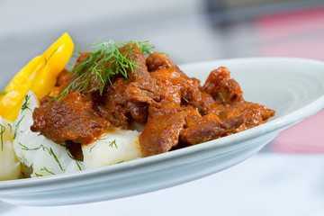 Beef stroganoff over boiled potatoes with pepper and dill