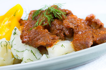 Beef stroganoff over boiled potatoes with pepper and dill