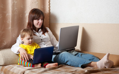 woman with toddler using laptops