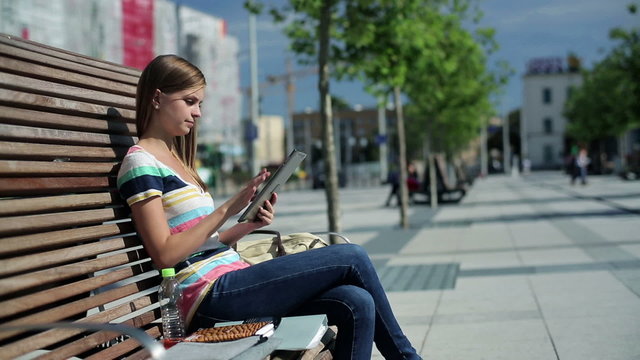 Young woman with tablet computer in the city, steadicam shot