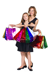 mother and daughter in elegant  dresses  with many colorful bags