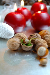 vier rote Adventskerzen und Nüsse