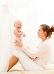 Mother and daughter play in the bedroom