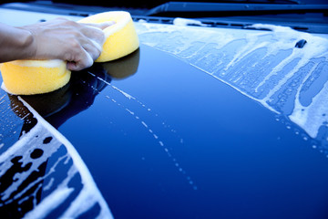 hand hold sponge over the car for washing