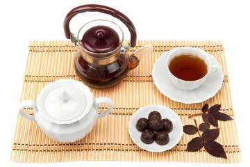 cup of tea and sweets in a saucer on the mat