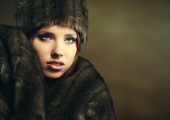 Fashion portrait of young pretty woman with fur