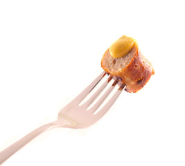 Bratwurst mit Senf auf einer Gabel