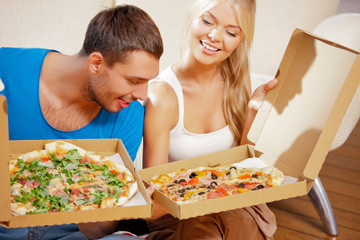 romantic couple eating pizza at home