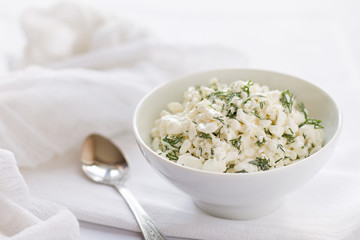 Cottage cheese served with dill on a white tablecloth