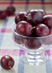 Raw plums served in a glass bowl