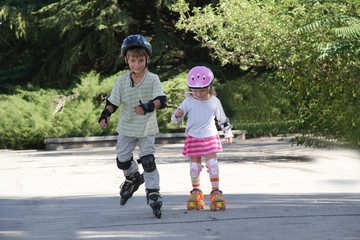 two happy children on roller blades outdoors © Alena Yakusheva