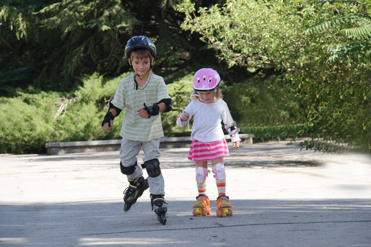 two happy children on roller blades outdoors