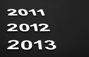 Upcoming years 2011, 2012 and 2013 as chrome digits over black b