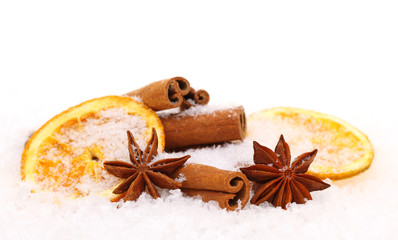 Fototapeta premium Zimtstangen Sternanis und Orangenscheiben mit Schnee bedeckt