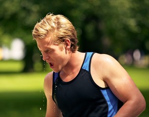 Fototapeta premium Young Athlete Refreshes Himself with Water