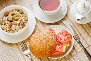 light breakfast with tea, fruit, sandwich and porridge