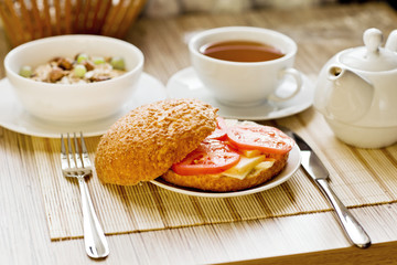 light breakfast with tea, fruit, sandwich and porridge