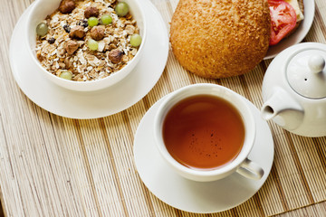 light breakfast with tea, fruit, sandwich and porridge
